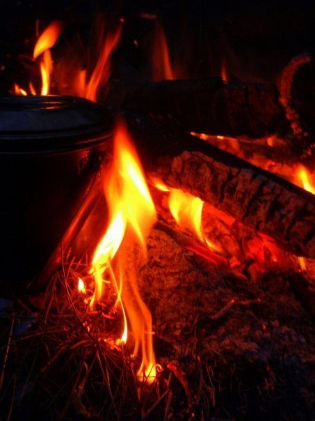 A billy can in the flames of a campfire